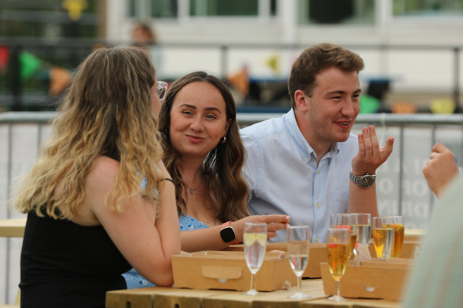 students sat at a table with drinks and picnic